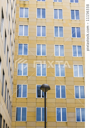 facade with blue mirroring windows and a street-light in front 11156338