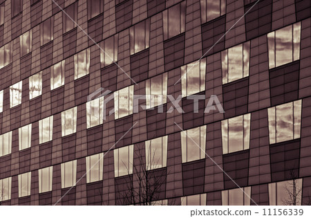 windows of a business house mirroring the sky, vintage color fil 11156339