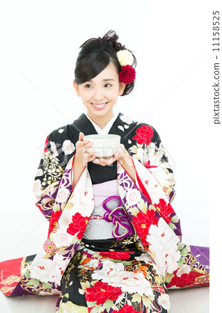 A woman in a kimono drinking green tea A woman in a kimono drinking green tea 11158525