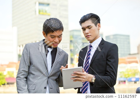 Young business executives looking at tablet in financial hub 11162597