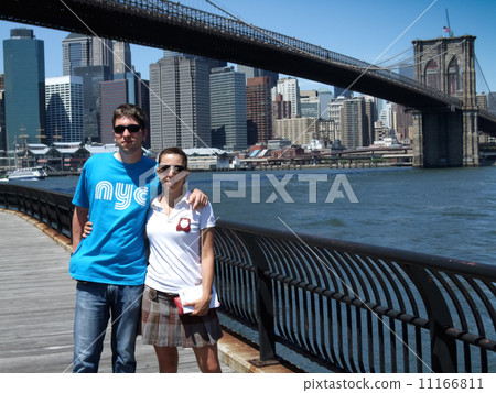 Young couple standing with arm around with Brooklyn Bridge in th Young couple standing with arm around with Brooklyn Bridge in th 11166811