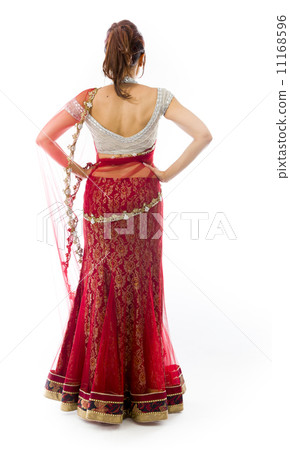 Rear view of a young Indian woman standing with her arms akimbo 11168596