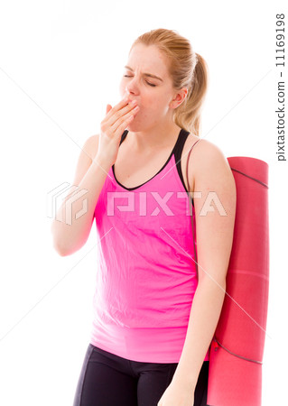 Young woman carrying exercising mat yawning Young woman carrying exercising mat yawning 11169198