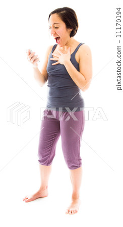 Young woman text messaging on mobile phone and looking surprised Young woman text messaging on mobile phone and looking surprised 11170194