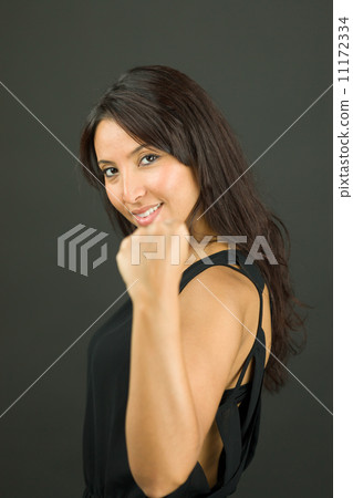Excited young woman showing fist and celebrating success Excited young woman showing fist and celebrating success 11172334