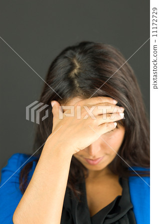 Upset young businesswoman with her head in hands 11172729