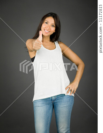 Young woman standing with hand on hip and showing thumb up sign 11172815