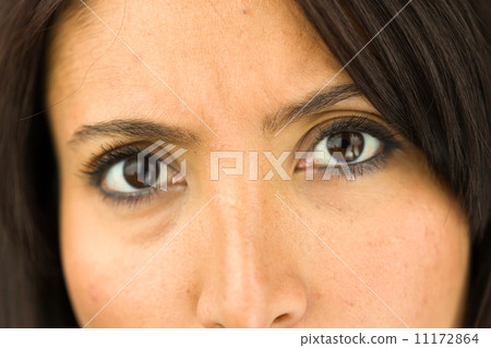 Extreme close-up of a young woman looking angry and disappointed Extreme close-up of a young woman looking angry and disappointed 11172864