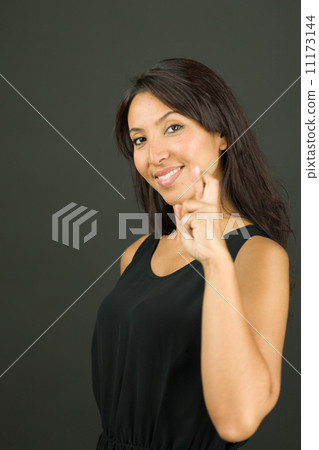 Portrait of a young woman showing her fingers crossed and smiling Portrait of a young woman showing her fingers crossed and smiling 11173144