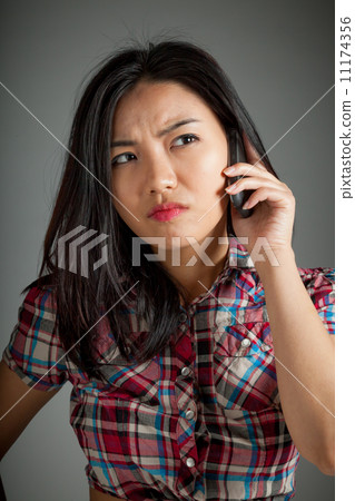 Portrait of sexy asian cowgirl upset on the phone Portrait of sexy asian cowgirl upset on the phone 11174356