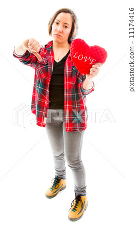 Young woman holding heart shape and showing thumbs down sign Young woman holding heart shape and showing thumbs down sign 11174416
