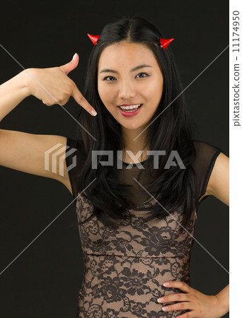Asian young woman dressed up as an devil pointing herself Asian young woman dressed up as an devil pointing herself 11174950