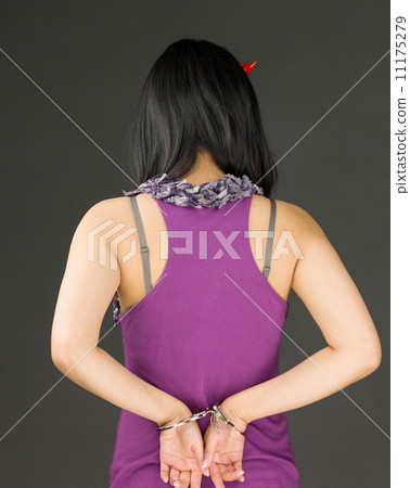 Rear view of devil side of a young Asian woman with handcuffs Rear view of devil side of a young Asian woman with handcuffs 11175279