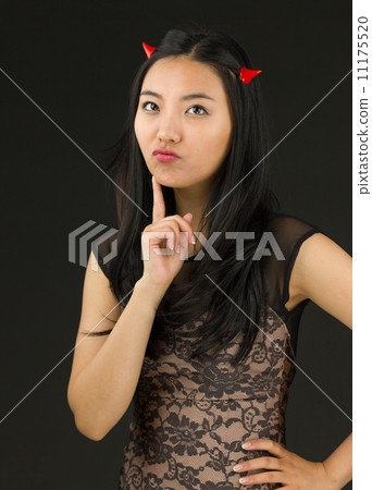 Asian young woman dressed up as an devil standing with hand on hip Asian young woman dressed up as an devil standing with hand on hip 11175520