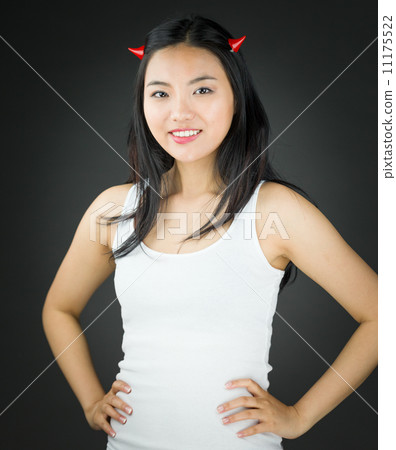 Asian young woman in devil horns pretending with her arms akimbo Asian young woman in devil horns pretending with her arms akimbo 11175522