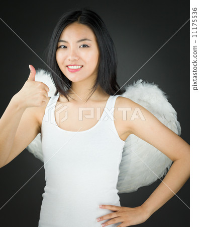 Happy Asian young woman dressed up as an angel with showing thumb up sign with hand on hip 11175536