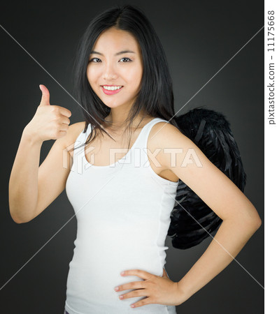 Happy Asian young woman dressed up as an angel with showing thumb up sign with her hand on hip 11175668