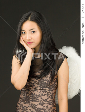 Asian young woman dressed up as an angel with her hands on cheek Asian young woman dressed up as an angel with her hands on cheek 11175854