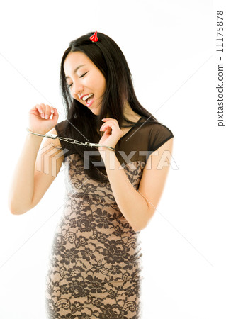 Happy Asian young woman dressed up as a devil with handcuffs isolated on white background 11175878