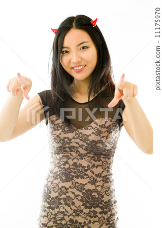 Asian young woman dressed up as a devil and pointing towards camera with both hands isolated on white background 11175970