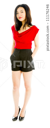 Portrait of a young woman standing with her hands in pockets 11176246
