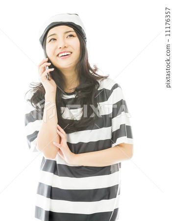 Young Asian woman talking on a mobile phone in prisoners uniform 11176357