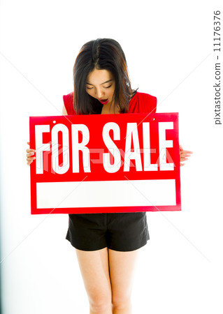 Saleswoman holding a for sale sign Saleswoman holding a for sale sign 11176376