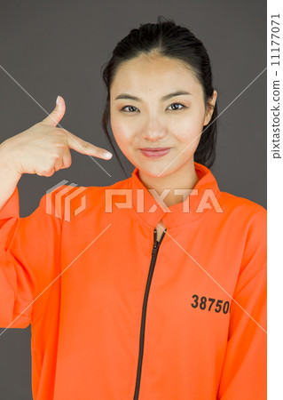 Young Asian woman pointing herself in prisoners uniform 11177071