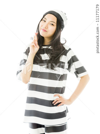Young Asian woman in prisoners uniform standing with finger crossed Young Asian woman in prisoners uniform standing with finger crossed 11177179