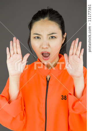 Young Asian woman making stop gesture sign from both hands in prisoners uniform 11177361