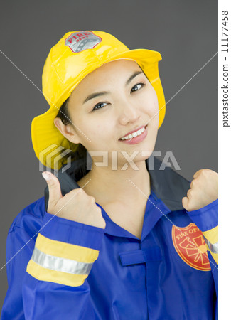 Close up of a confident lady firefighter showing thumbs up sign 11177458
