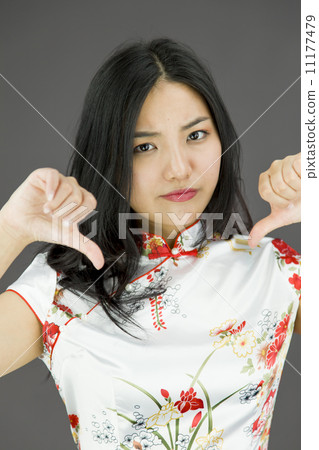 Unhappy Asian young woman giving thumbs down gesture Unhappy Asian young woman giving thumbs down gesture 11177479