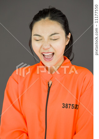 Young Asian woman shouting in excitement and wearing prisoners uniform Young Asian woman shouting in excitement and wearing prisoners uniform 11177550