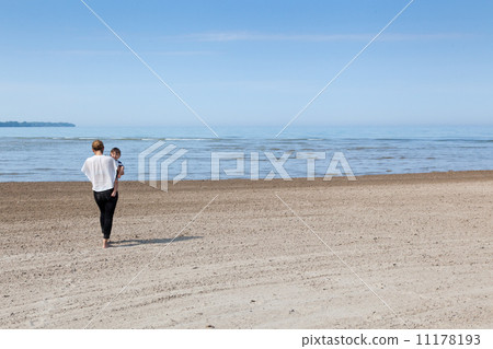 Woman carrying her son on the beach, Georgian Bay, Tobermory, On Woman carrying her son on the beach, Georgian Bay, Tobermory, On 11178193