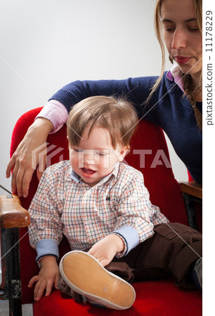 Boy and his mother sitting on chairs and playing Boy and his mother sitting on chairs and playing 11178229