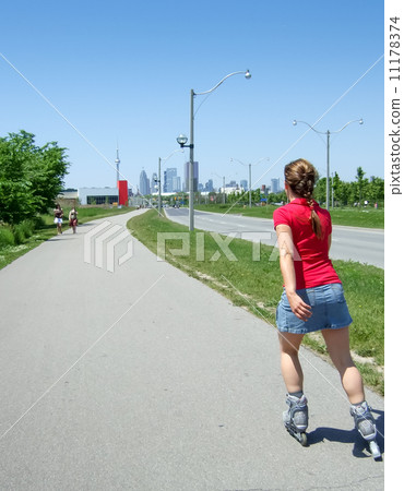 Rear view of a woman skating in a street, Toronto, Ontario, Cana 11178374