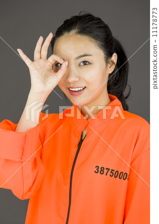 Young Asian woman showing OK sign in prisoners uniform 11178773