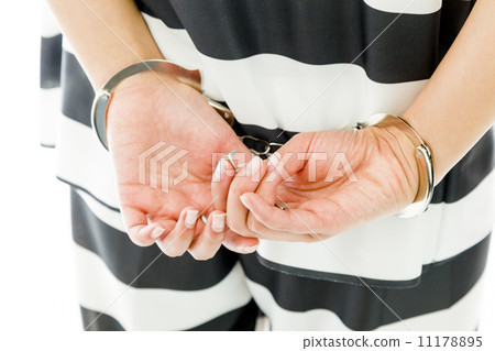Midsection of a handcuffed Asian young woman in prisoners uniform Midsection of a handcuffed Asian young woman in prisoners uniform 11178895