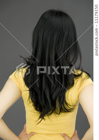 Rear view of a young Asian woman with her arms akimbo 11179150