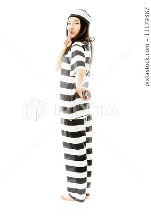 Young Asian woman standing with finger on lips in prisoners uniform Young Asian woman standing with finger on lips in prisoners uniform 11179387