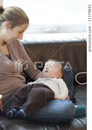 Baby boy sleeping in the lap of his mother 11179642