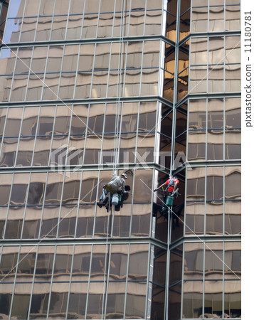Two window washers cleaning outside of modern corporate building 11180781