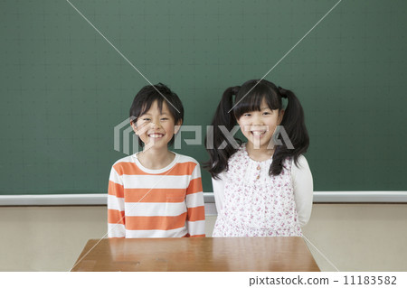 Elementary school students standing in front of the blackboard Elementary school students standing in front of the blackboard 11183582