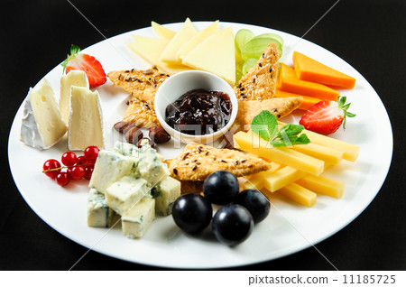 Platter with different types of cheese, fresh fruits and sauce 11185725