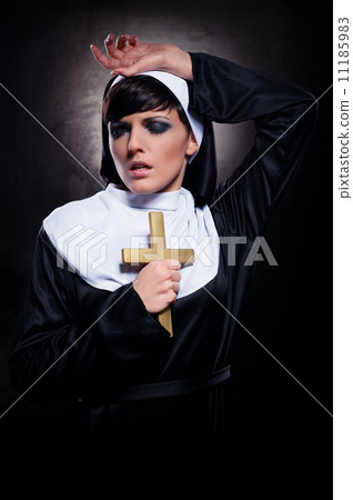 Young attractive nun holding a cross Young attractive nun holding a cross 11185983