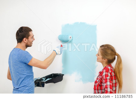 smiling couple painting wall at home 11186785