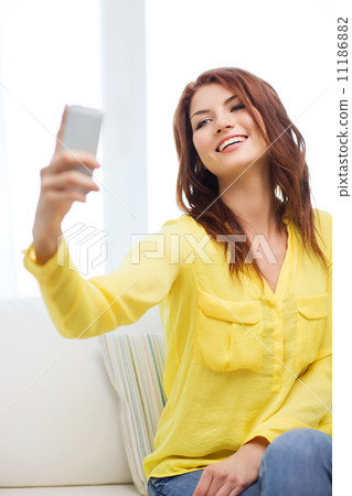 smiling woman with smartphone at home smiling woman with smartphone at home 11186882