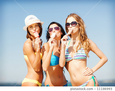 girls in bikinis with ice cream on the beach 11186993