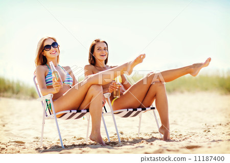 girls with drinks on the beach chairs girls with drinks on the beach chairs 11187400