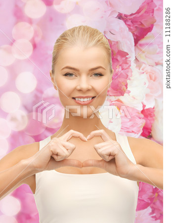 smiling young woman showing heart shape gesture smiling young woman showing heart shape gesture 11188286